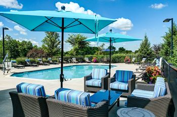 a swimming pool with lounge chairs and umbrellas
